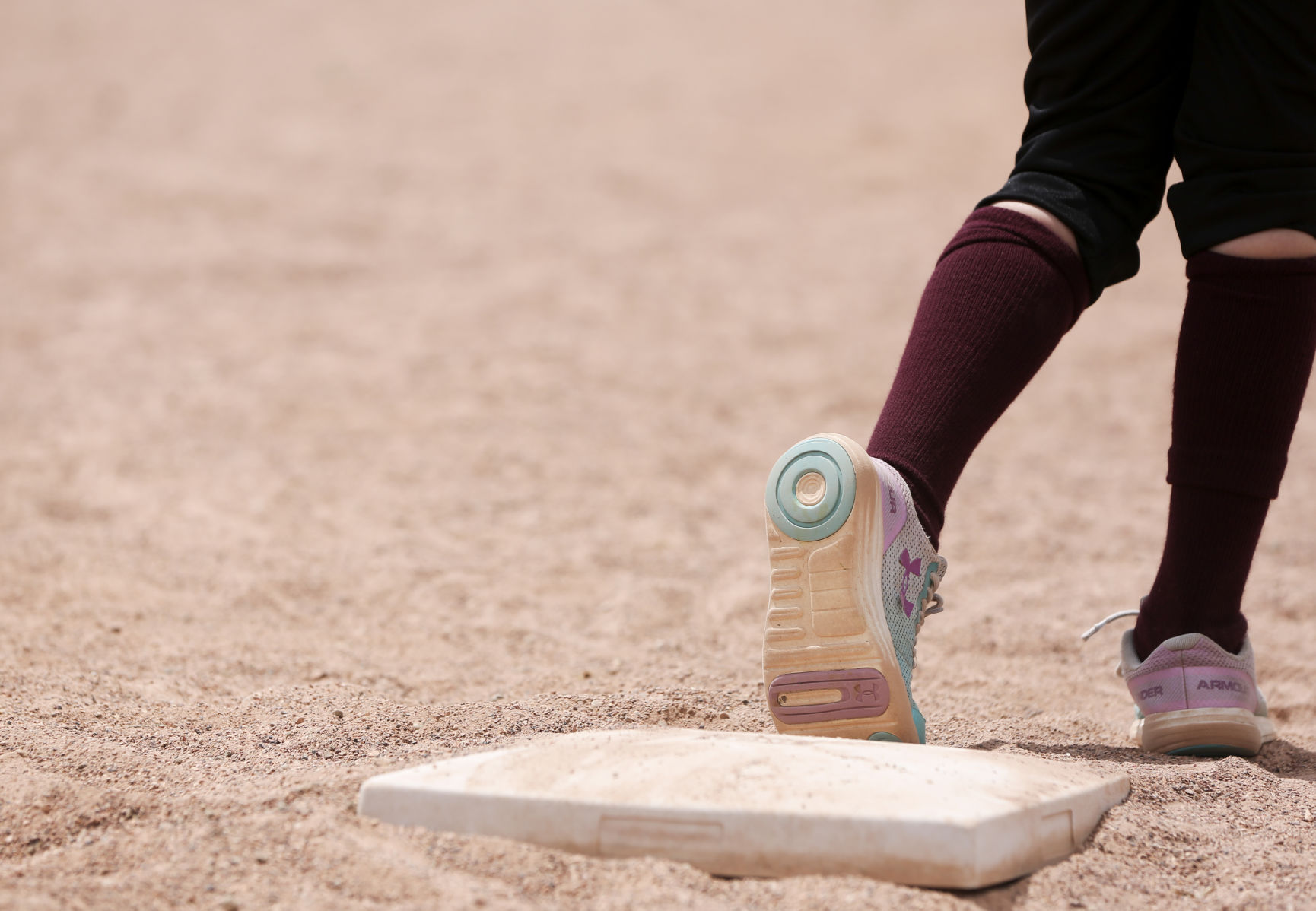 Emery Cox waits on third base in anticipation of taking her lead toward home